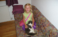 Kind mit Katze auf dem Sofa